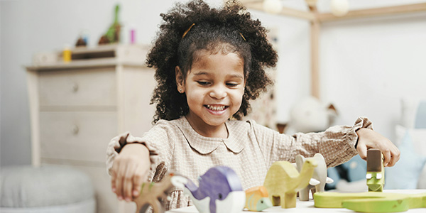 Small girl playing with her dinosaur toys, represents how you can support your child through children & teens therapy in Montclair, NJ.