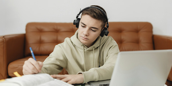 Teen boy studying, looking focused and confident, represents how executive functioning coaching in NJ and NYC can support your needs and goals.
