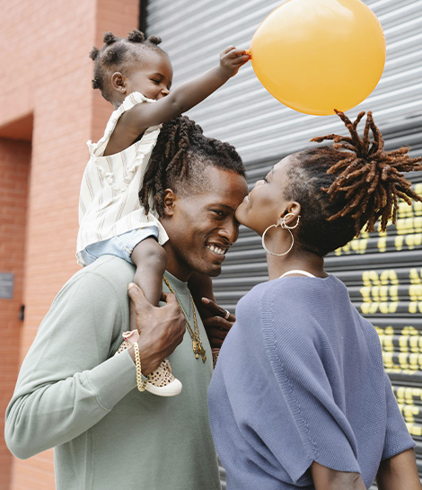 Happy family with child holding a ballon, represents how family therapy prevent and work through conflicts.